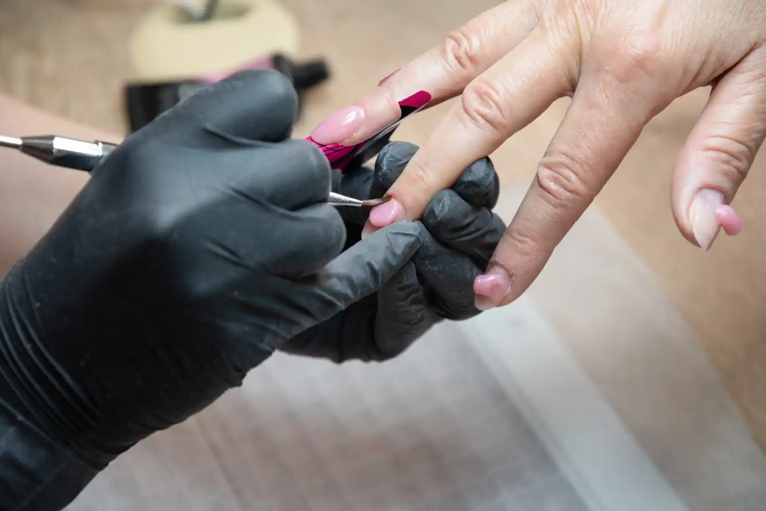 Nail technician shaping natural nails during a gel manicure